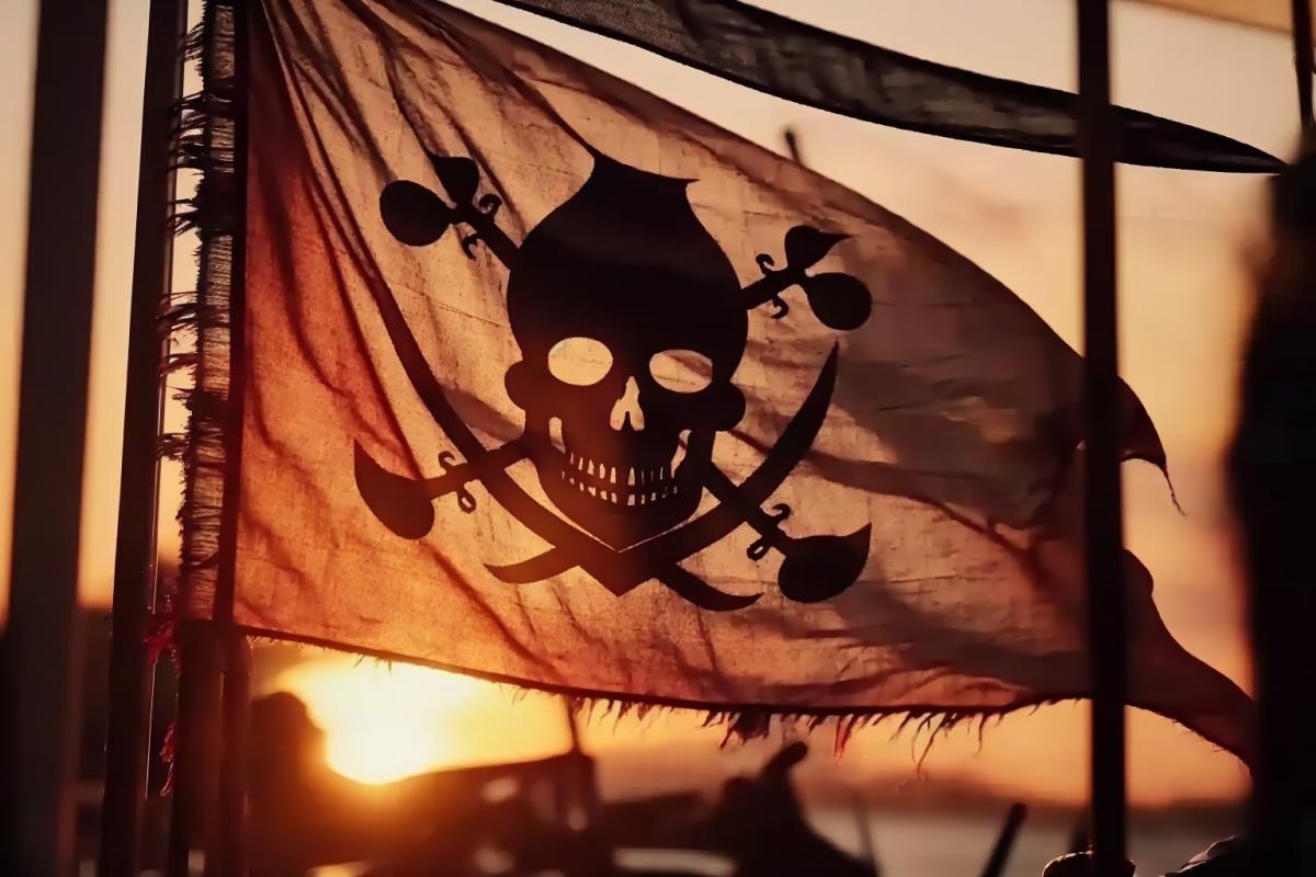 pirate flag Jolly Roger flutters on the mast of a pirate schooner, close-up, bullet and fire marks, wind, sunset, glare on the water