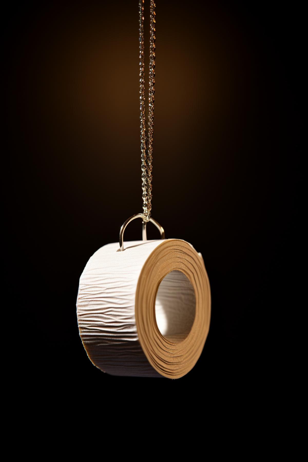 Precious pendant in the form of a toilet paper roll, photorealism