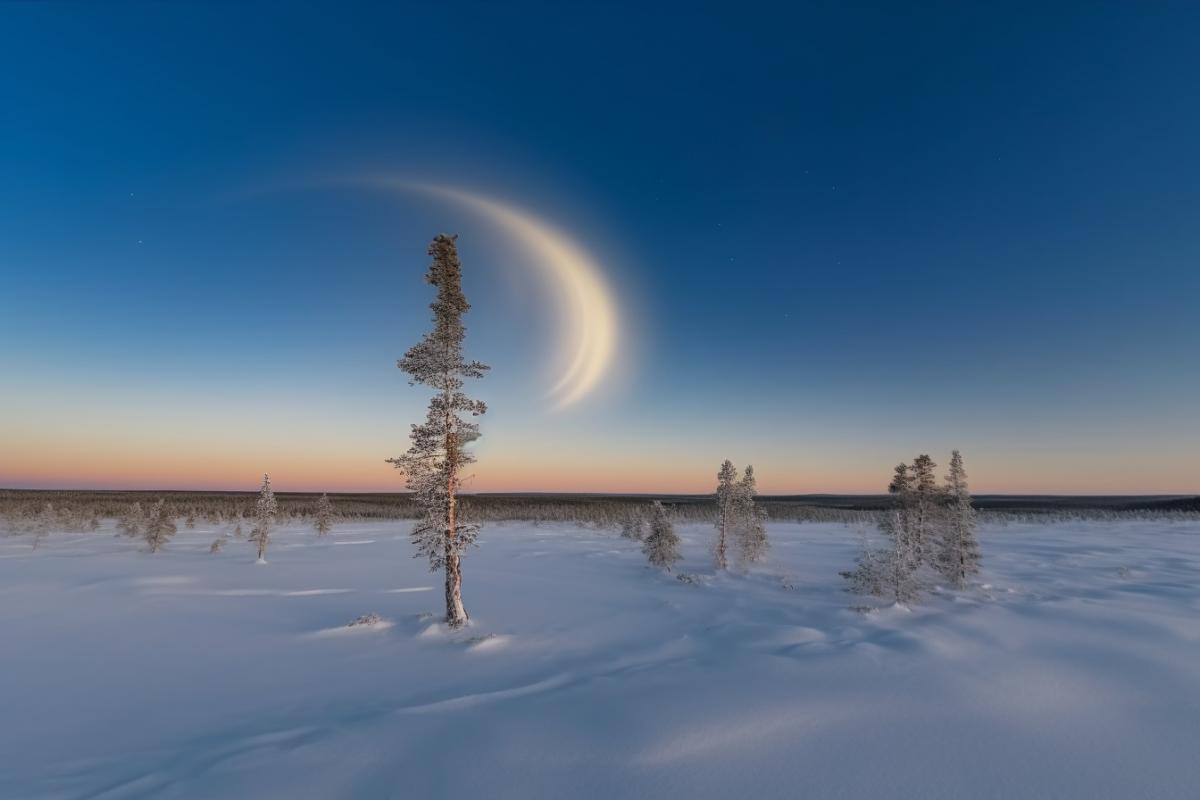 Moonlight rainbow, fantastic atmosphere, enigmatic winter border of a wood, superlune