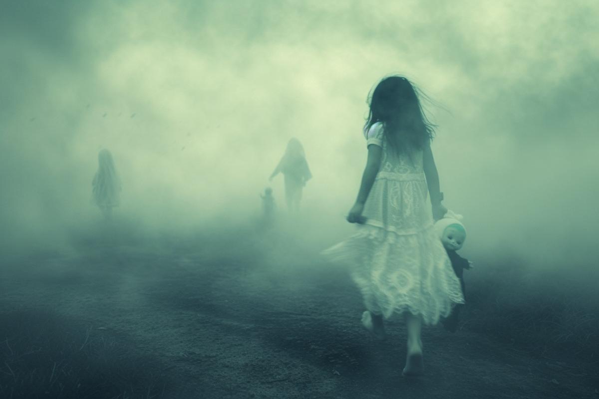 A little girl in a white dress clutches a doll to her detailed and walks among the thick fog, in the fog she is attacked by ghosts and ghosts