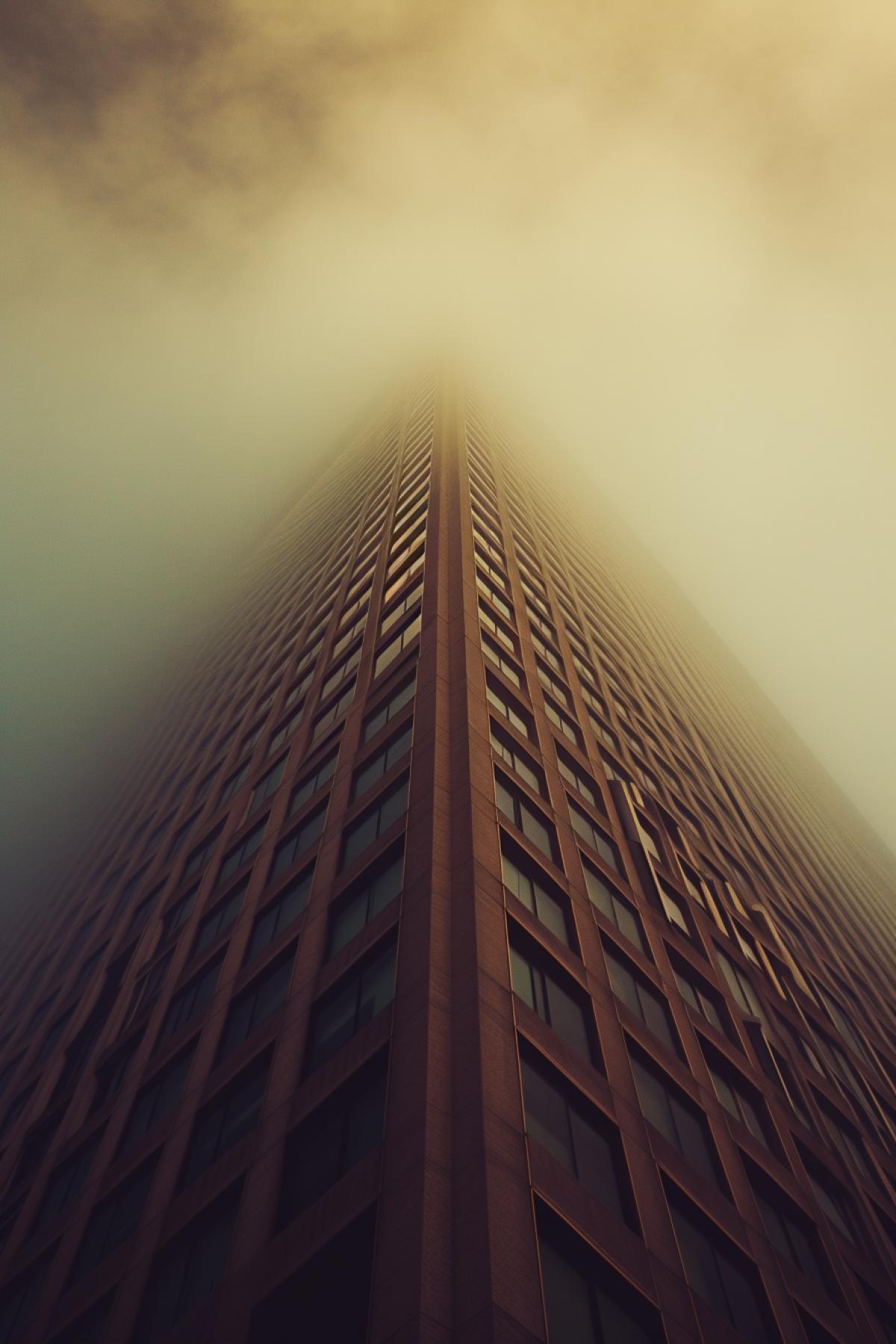 a tall building is shown in the fog that is surrounding it, in the style of angular abstraction, joel robison, soft minimalism, the san francisco renaissance., dramatic diagonals, crisp and clean, matte photo
