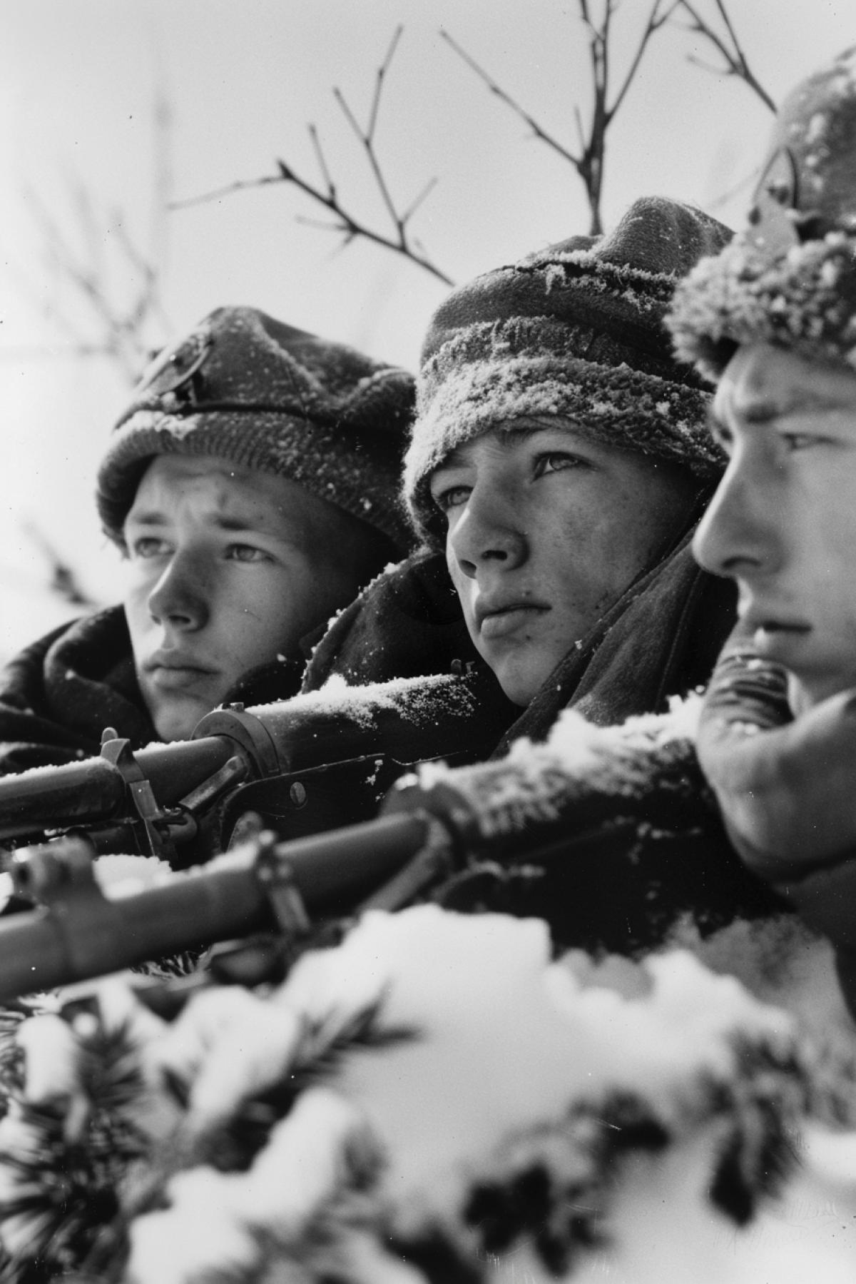 Several exhausted tired teenagers defending their motherland from German germans poor clothes old machine guns winter Russia 1942