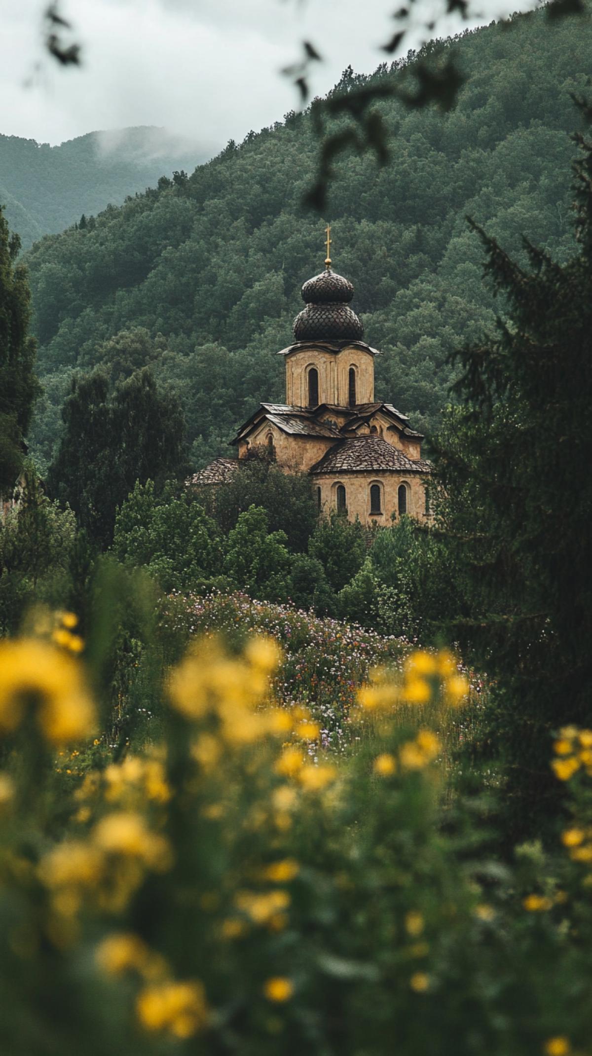 Church-monastery in a mountainous area surrounded by flower thickets and trees