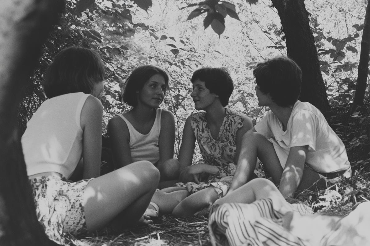a group of people having a rest in nature, photographed in the 80s on dark and white film from the Kazan Tasma plant