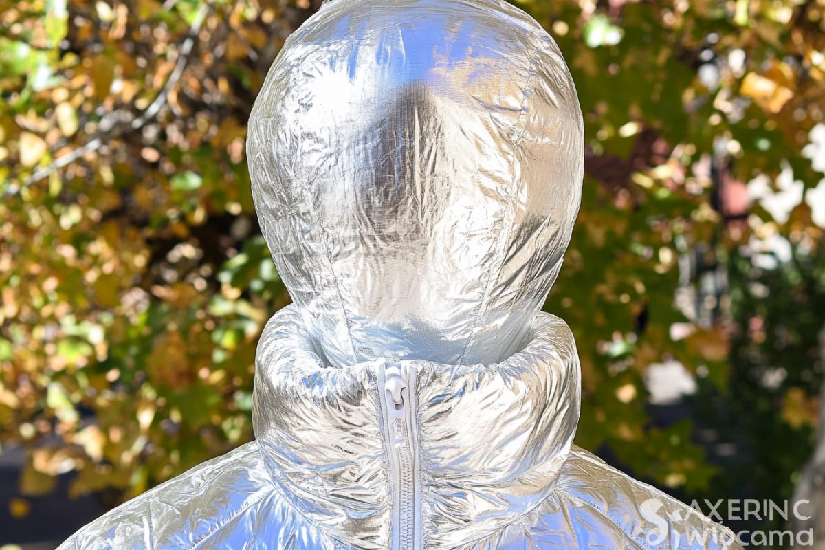 Creative advertising of a down jacket, in the photo deltaPlainer, who plans against the sky, shooting from the ground, instead of a deltaplane a cool modern fashion down jacket
