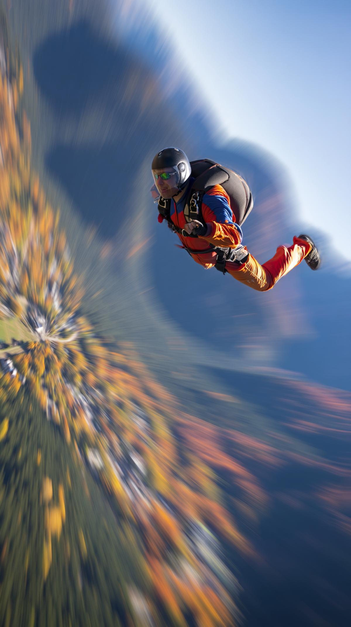 fast-paced skydiving shot, blur motion, intense colors, freedom, exhilaration, stunning scenery