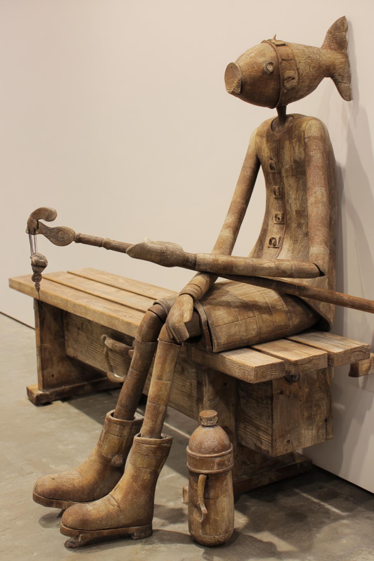 Fish Hammer in the form of a woman in a resting on a bench