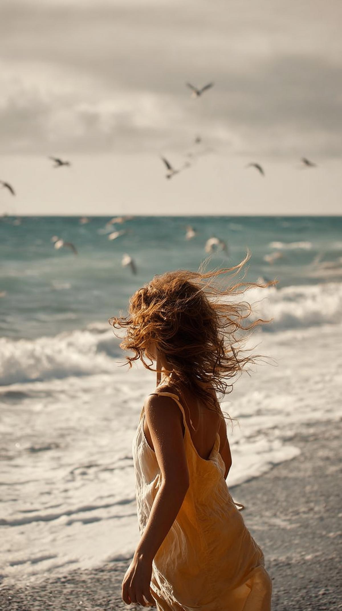 The atmosphere of the seashore. photo session of a girl on the seashore on the seashore: a light breeze plays with her hair, the air is filled with the salty scent of the waves, photo from nat geo wild magazine, high resolution, high quality