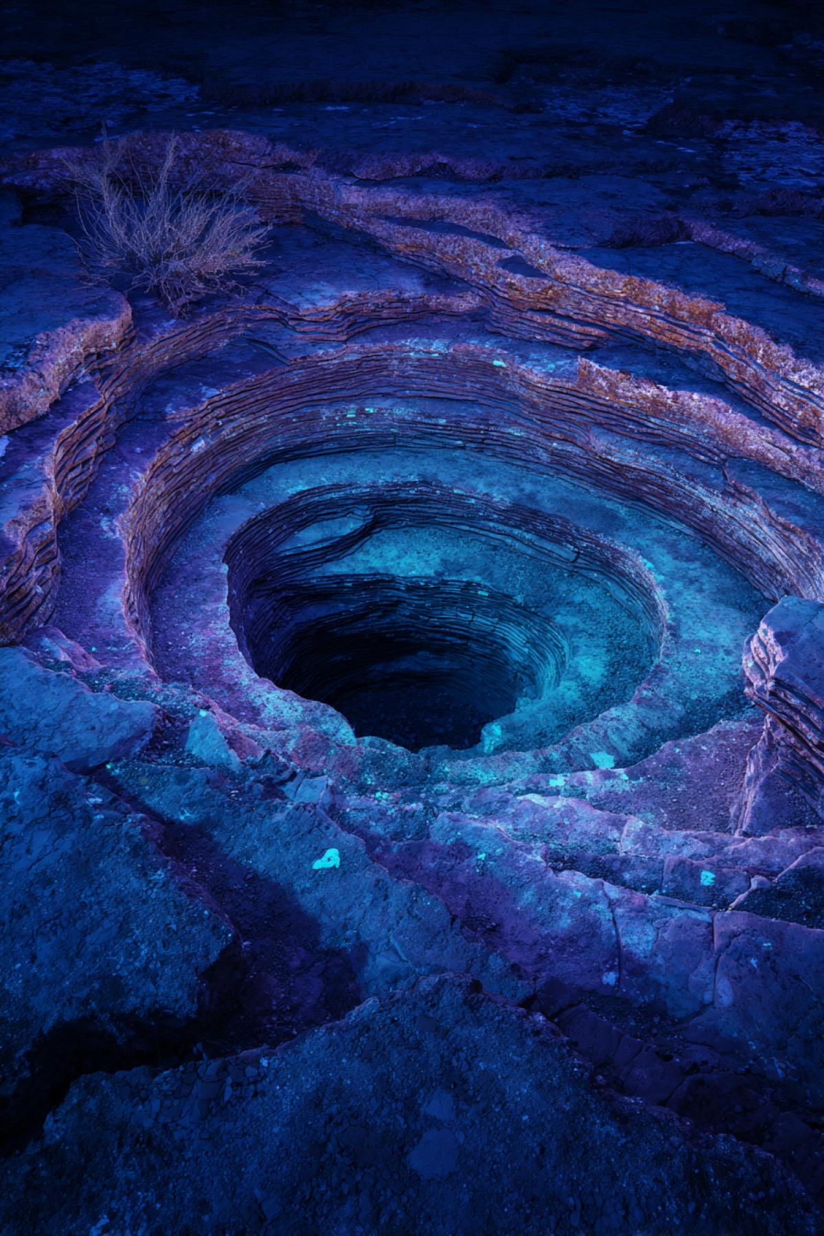 Petrified tsunami crater in Arizona, its concentric rings glowing under UV light at night