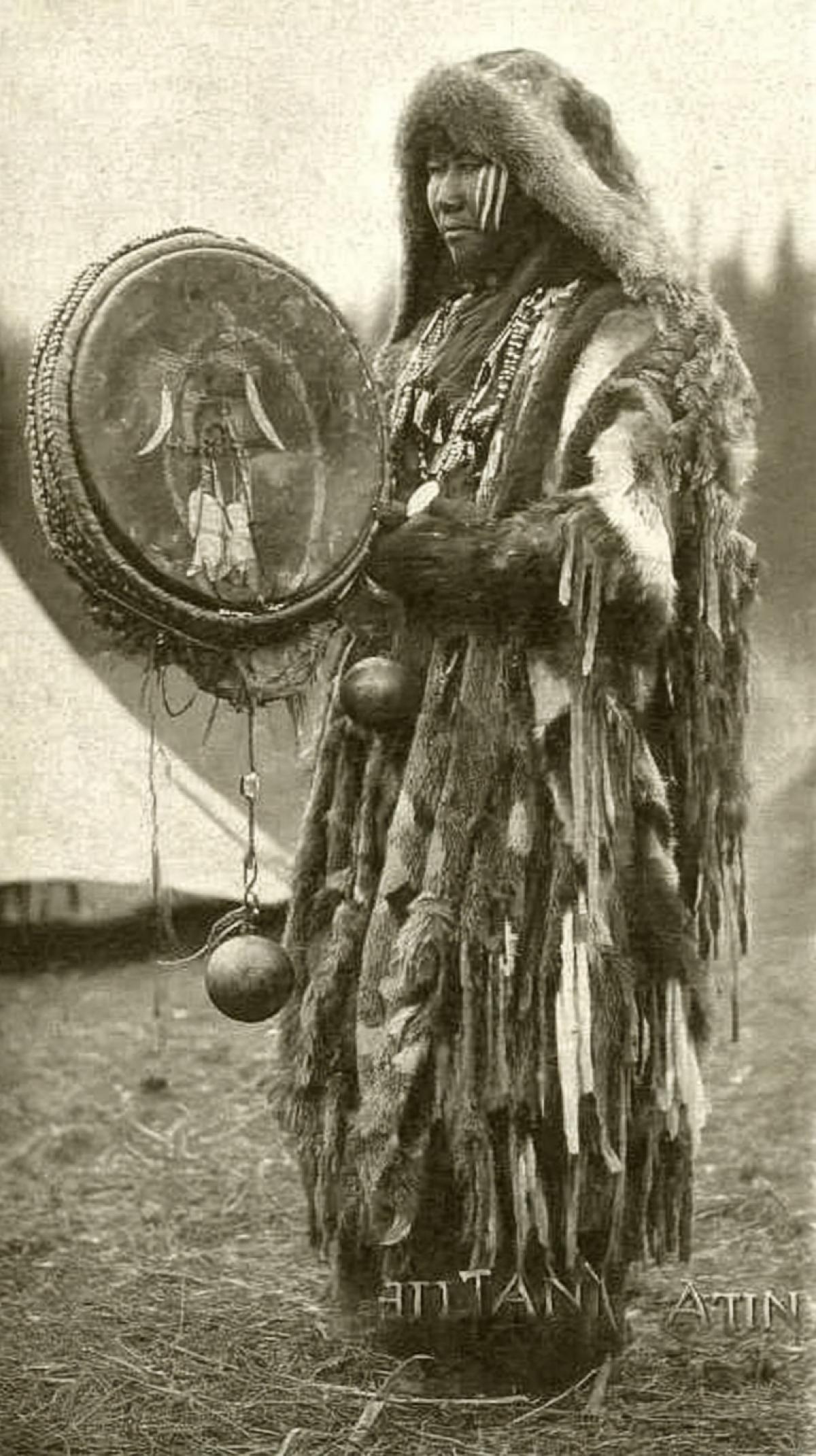 SHAMAN WITH HIS DRUM AND BELL. Shaman or healer from the Altai Mountains. Fully dressed, with a beautiful drum and image, he. is ready to call the weather gods on behalf of his people. dark and white photo, sepia. text below \" Altai \"