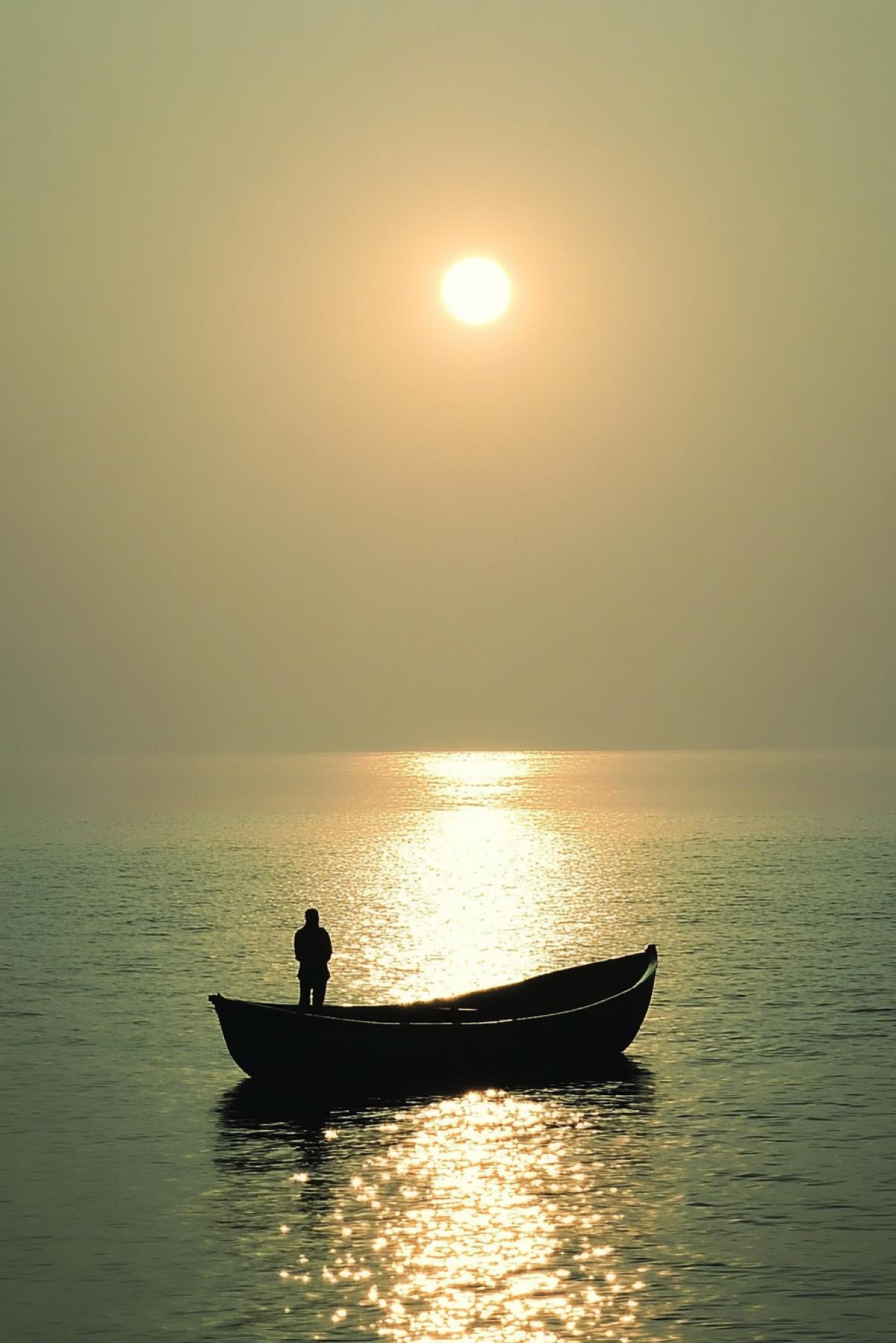 A small boat with a man standing in it, looking at the horizon. The boat is sailing on the sea against the backdrop of the setting sun and a light green sky. The water reflects the golden glow of the sunset, creating an atmosphere of calm and harmony. This scene conveys serene beauty and peace, evoking a sense of peace and reflection in the style of Claude Monet. sref 2261307605chaos 10 stylize 150