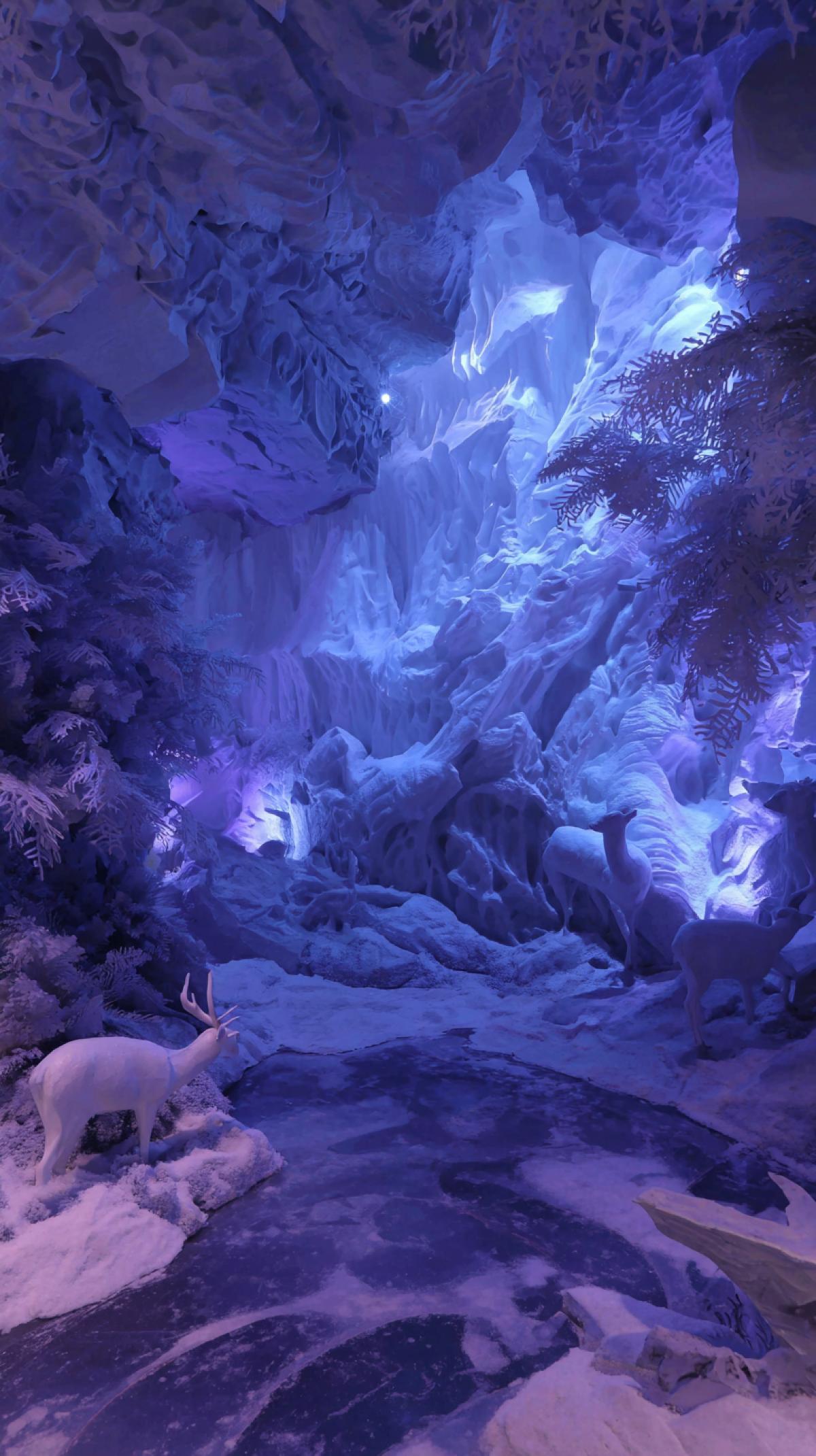 The interior of the ice cave with animals, for example, deer, dragon, dinosaur. The scale, ice texture and the game of light are rays, walls, crystalline formations, frozen stalactites/stalagmites, reflection in reservoirs inside the cave, traces of humans and animals. All in neon light.