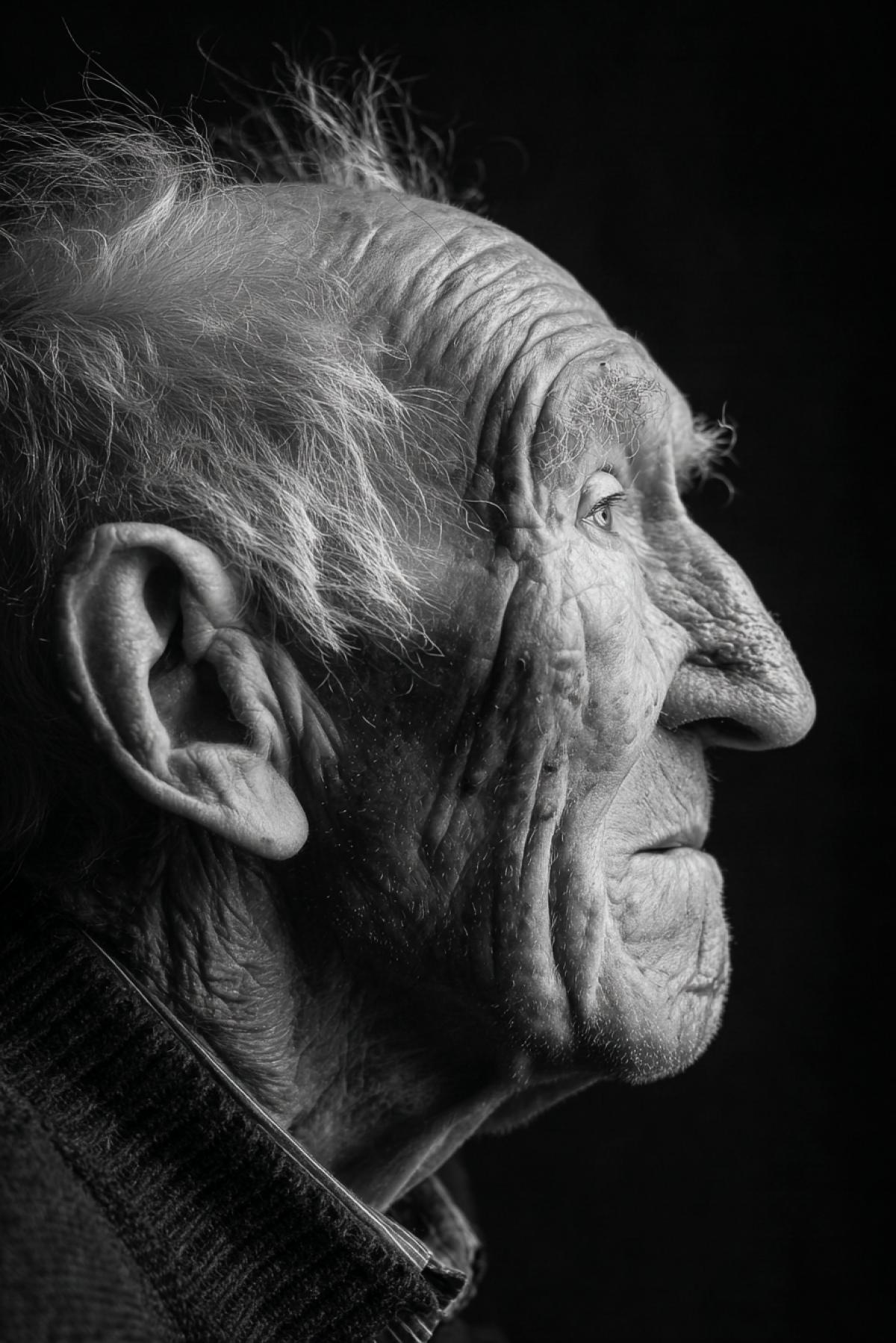 Old wise experience wrinkled person 90 year old fun eyes Portrait in profile