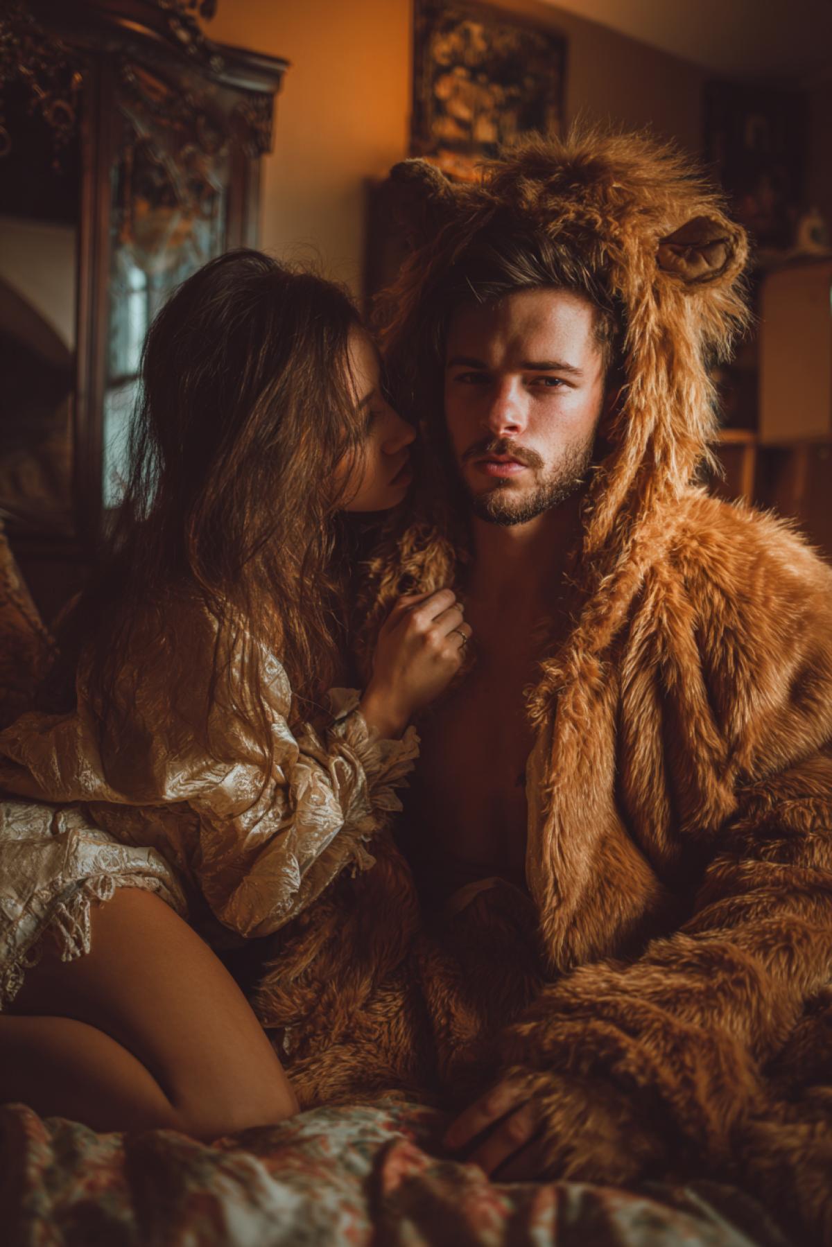 Handsome man wearing fur costume of lion in cosy bedroom with his fancy 23yo beautiful girl love tender touches