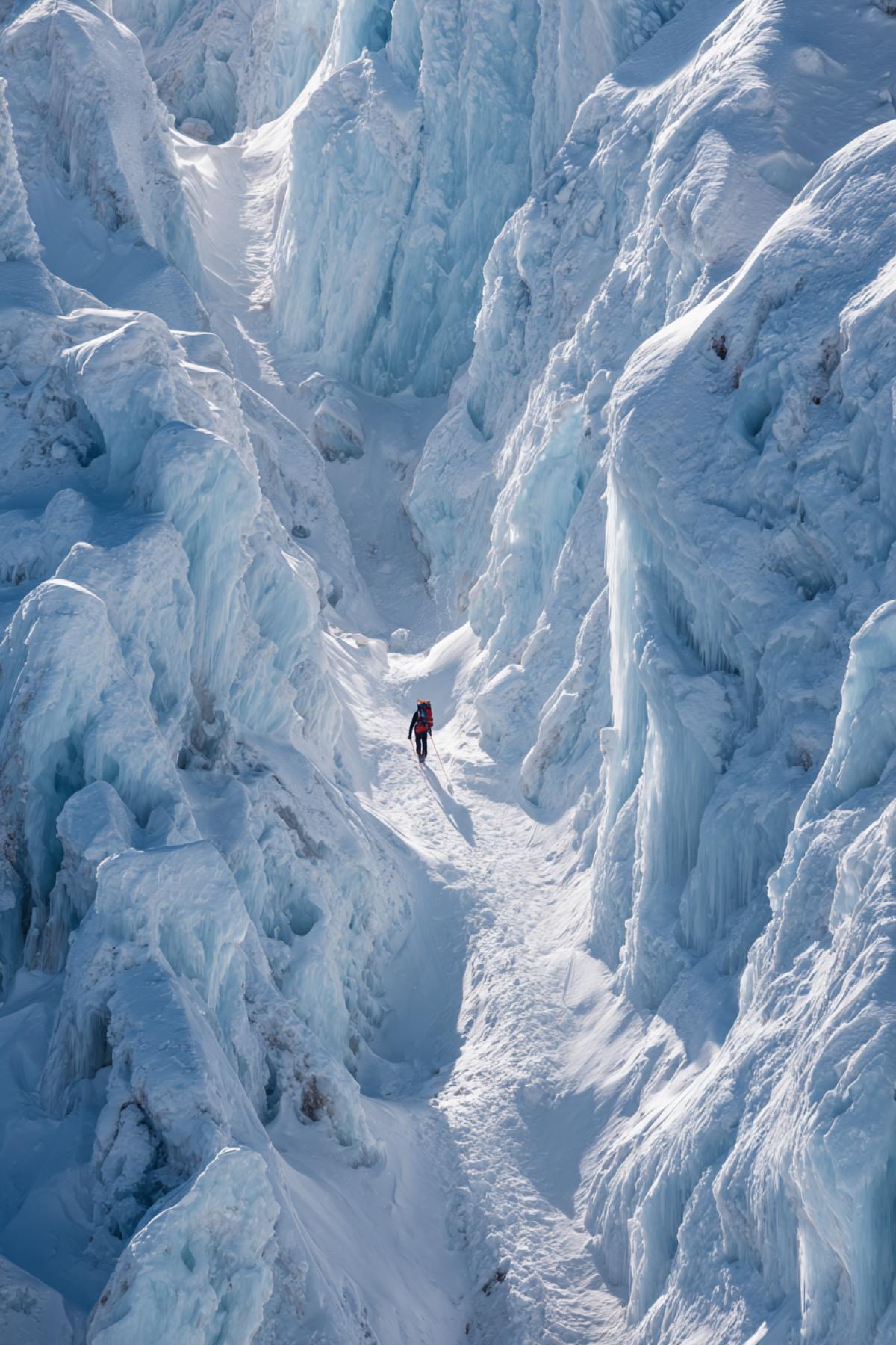 A climber traverses a narrow ridge of pristine blue ice on a terrifyingly high mountain pass. They are a small spot of color in a world of brilliant white and deep blue. The early morning light creates a magical glow through the intricate ice formations and seracs that look like a frozen cathedral. The atmosphere is both dangerous and breathtakingly beautiful. Hyperrealistic, National Geographic photo, extreme alpine environment, crisp air, sense of awe and adventure, frozen mist, ultra-detailed, 32k