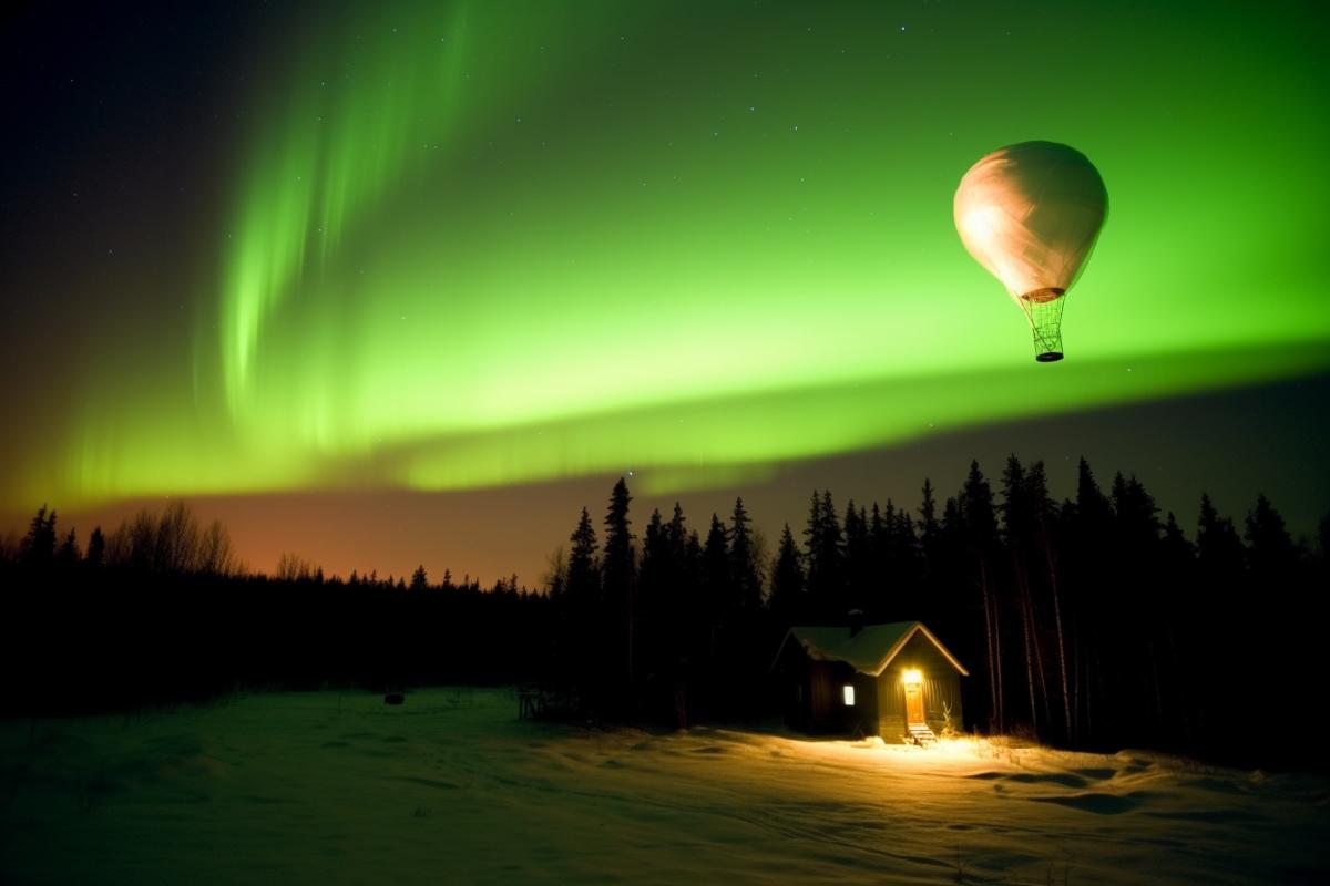 The balloon glows at night against the background of the northern lights, winter in Karelia