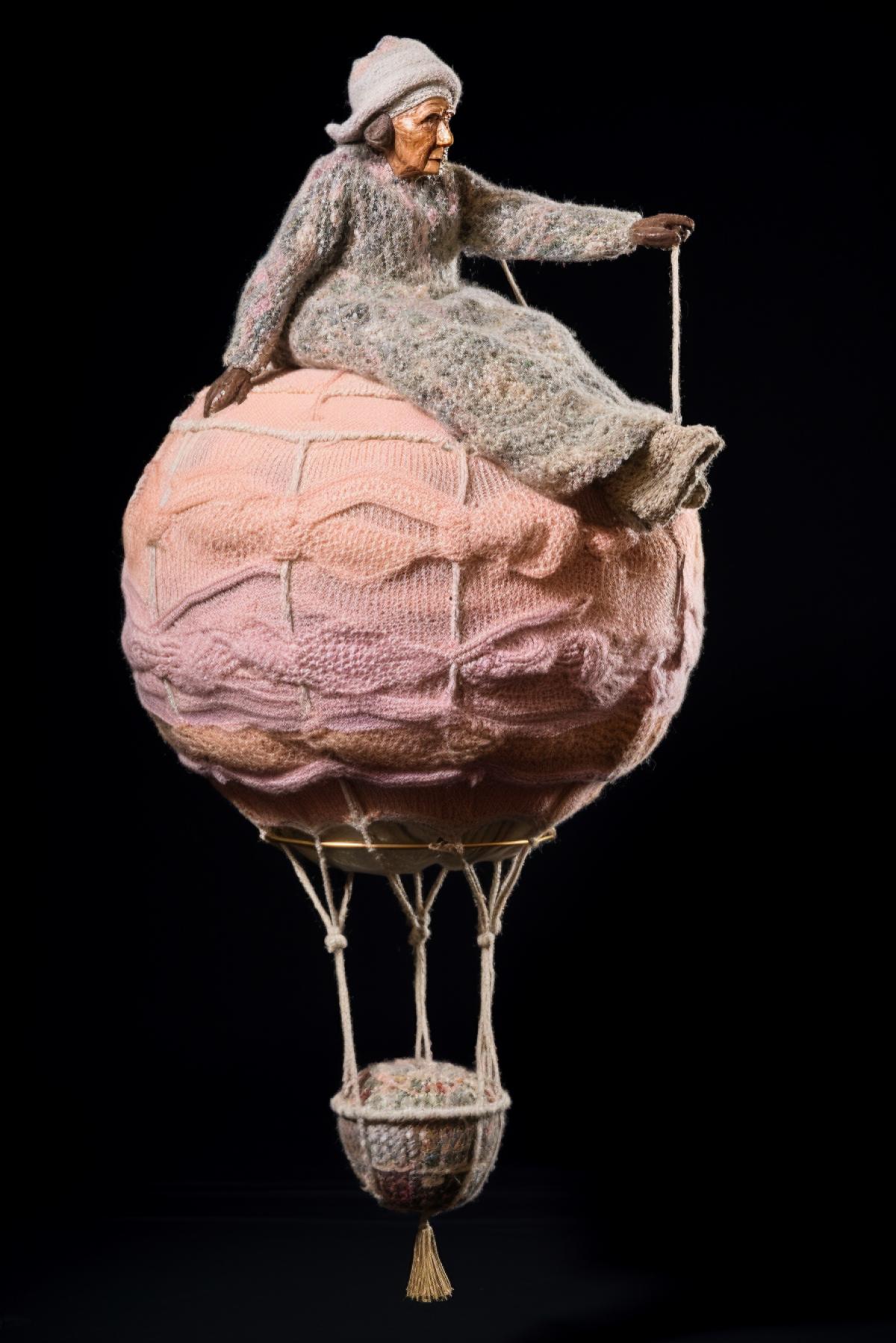 Granny in a knitted sweater flies on a knitted balloon
